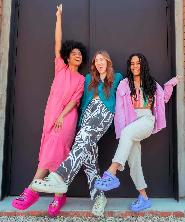 Three women wearing Crocs